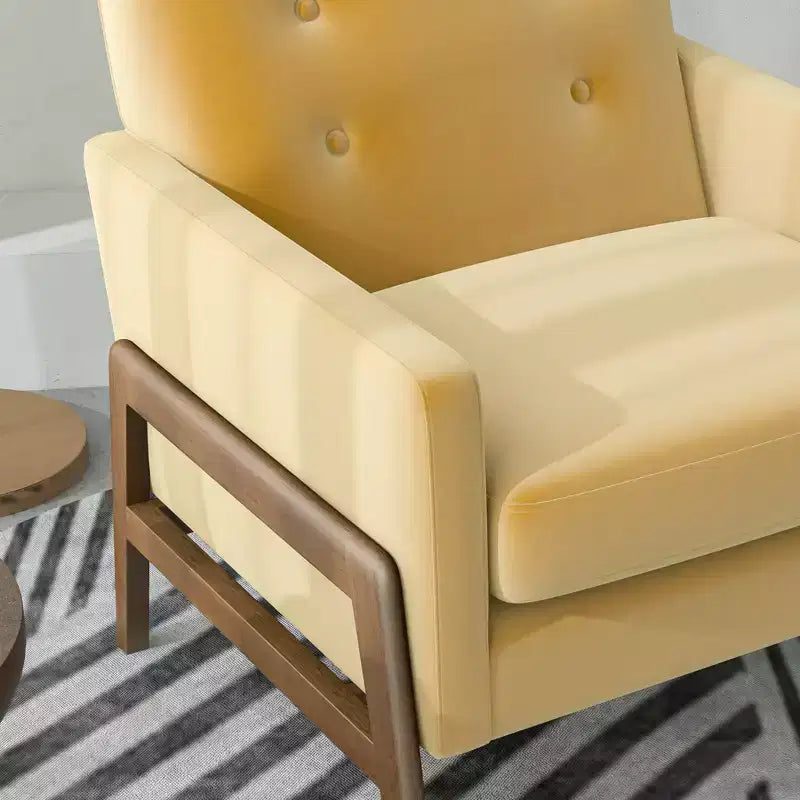 Fauteuil moderne en velours avec dossier capitonné et pieds en bois massif