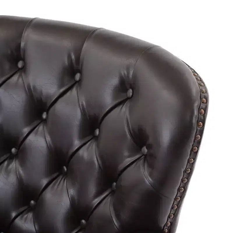 Un fauteuil inclinable capitonné de style vintage orné de rivets et de pieds en bois