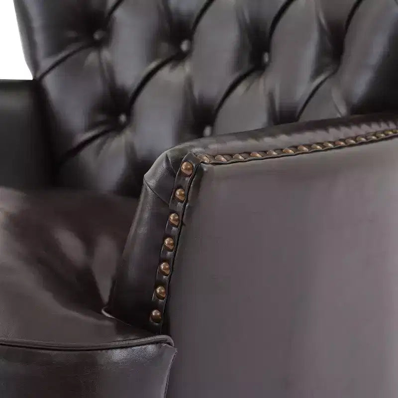 Un fauteuil inclinable capitonné de style vintage orné de rivets et de pieds en bois