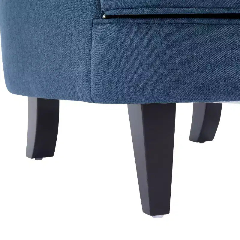 Un fauteuil inclinable capitonné de style vintage orné de rivets et de pieds en bois