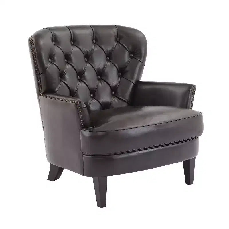 Un fauteuil inclinable capitonné de style vintage orné de rivets et de pieds en bois