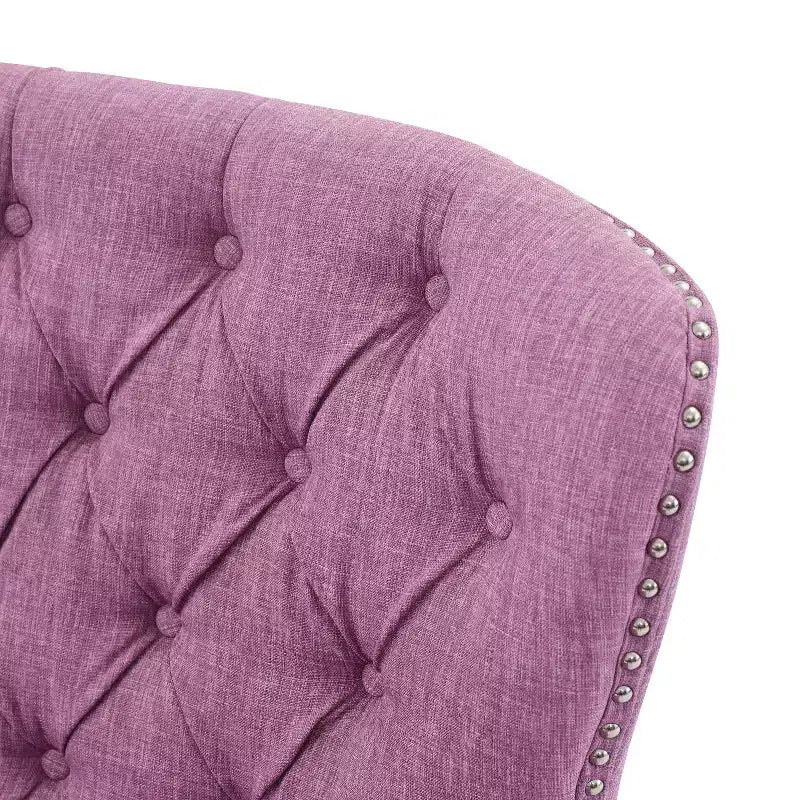 Un fauteuil inclinable capitonné de style vintage orné de rivets et de pieds en bois