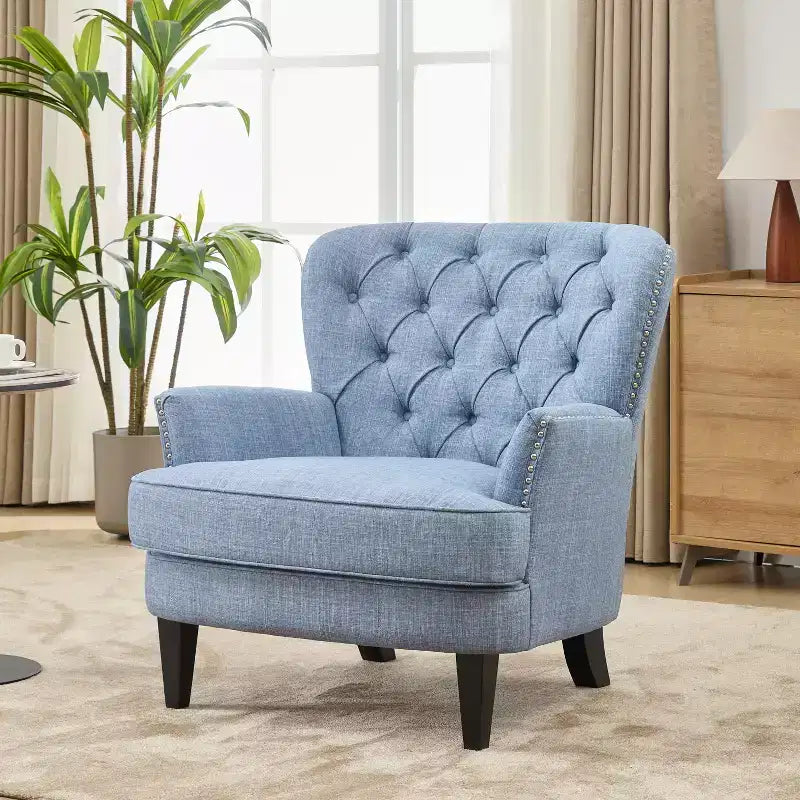 Un fauteuil inclinable capitonné de style vintage orné de rivets et de pieds en bois